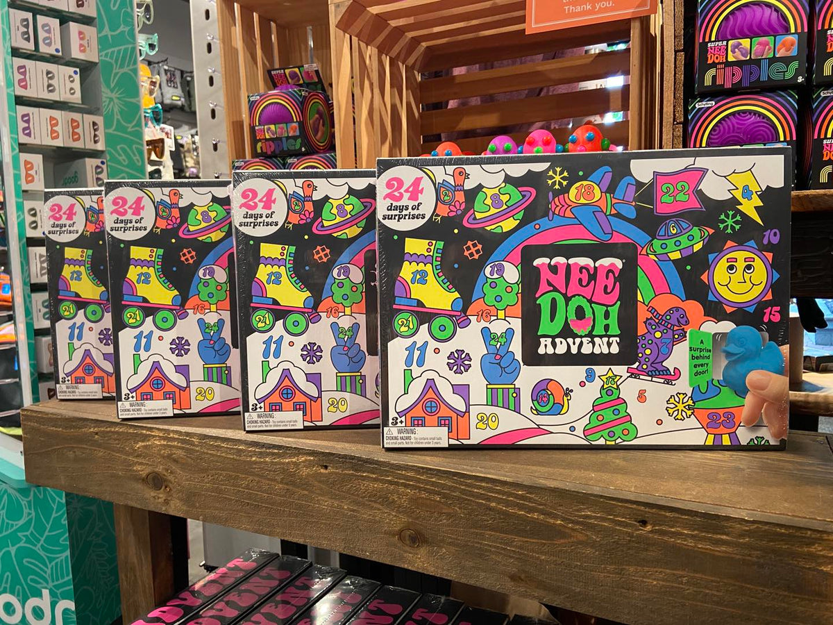 Four advent calendar boxes on a wooden shelf